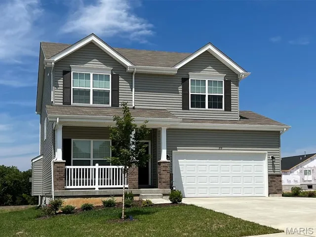 View of front of property with covered porch, brick siding, concrete driveway, and a garage