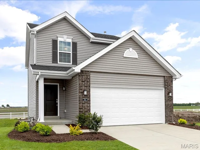 Traditional home with brick siding, concrete driveway, a garage, and a shingled roof