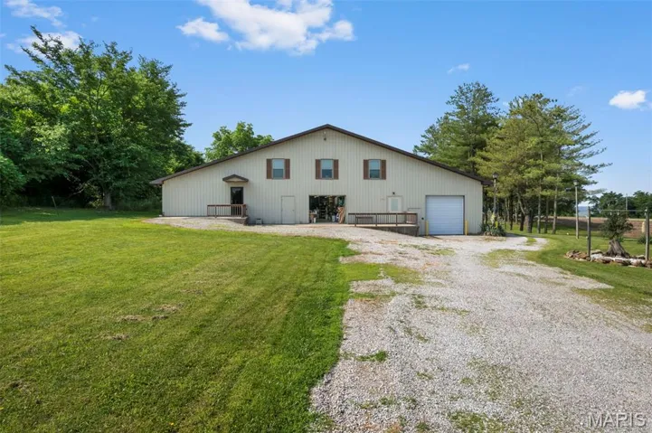 Rear view of house with a pole building, a lawn, an outbuilding, and a garage