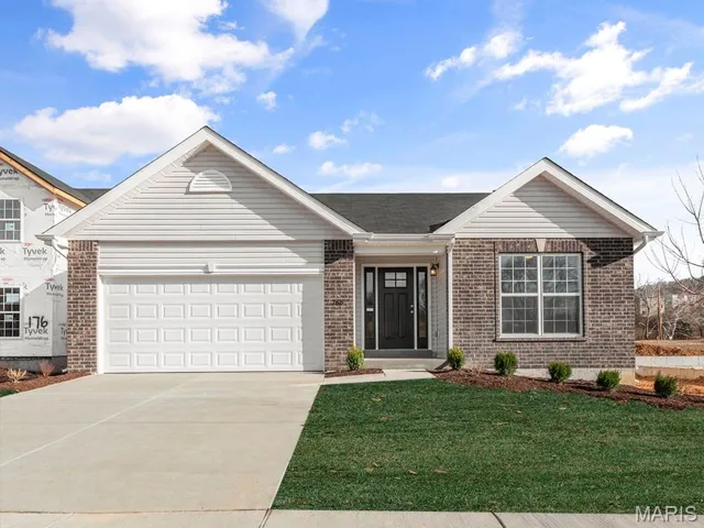 Ranch-style home with brick siding, concrete driveway, a garage, and a front yard