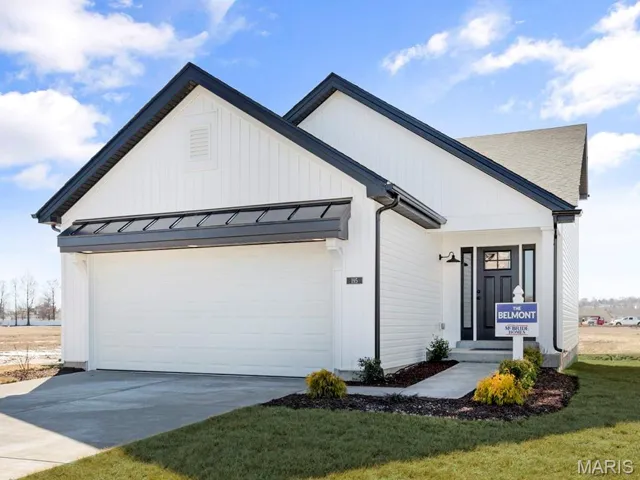 Modern farmhouse with a standing seam roof, concrete driveway, a garage, a front lawn, and metal roof