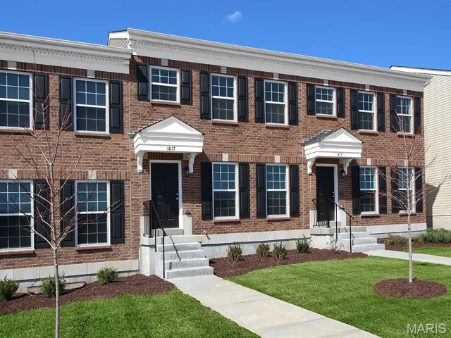 Colonial inspired home featuring brick siding and a front lawn