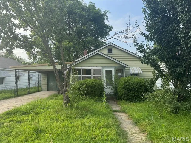 Single story home featuring driveway and an attached carport