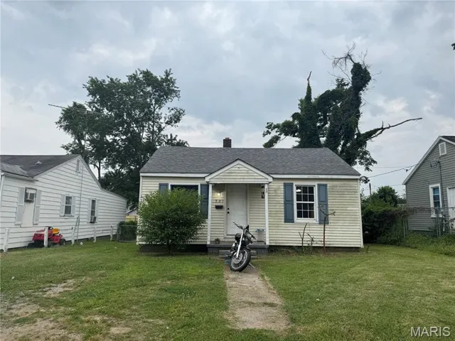 Bungalow featuring a shingled roof and a chimney