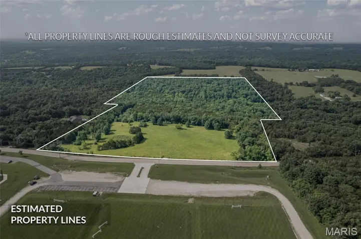 Aerial view of sparsely populated area featuring property boundaries highlighted and a heavily wooded area