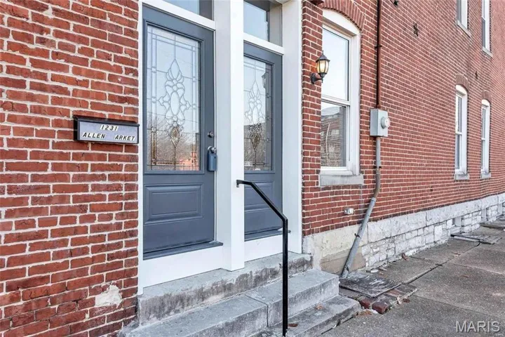 Entrance to property featuring brick siding