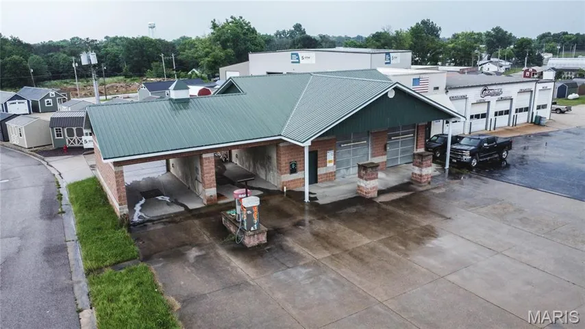 View of front of property featuring a metal roof and brick siding