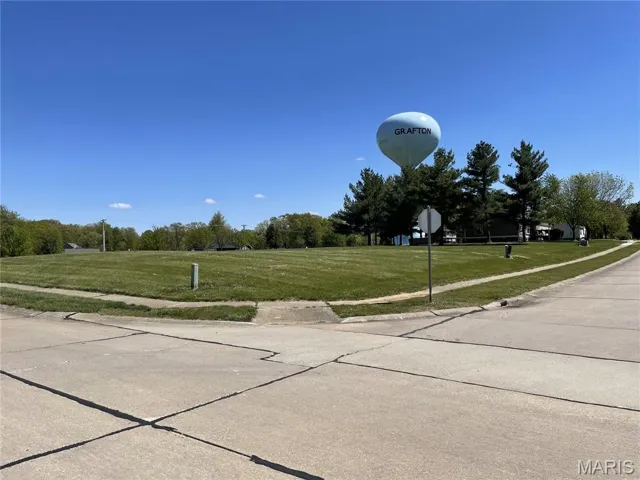 View of concrete road with sidewalks, traffic signs, and curbs