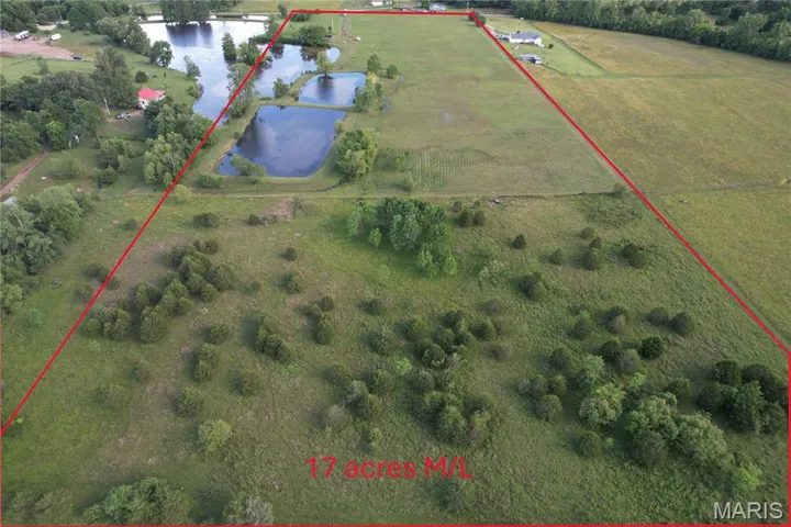 Aerial view of sparsely populated area featuring a large body of water and property boundaries highlighted