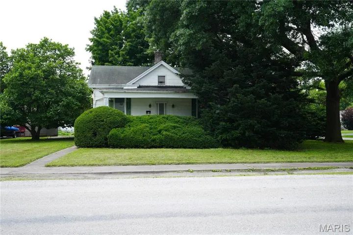 View of front of house with a chimney and a front lawn