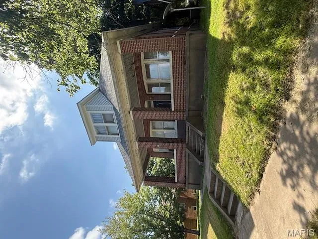 Bungalow-style house with brick siding, covered porch, and a front lawn