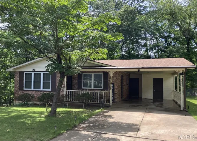Ranch-style house with concrete driveway, a carport, a front yard, and brick siding