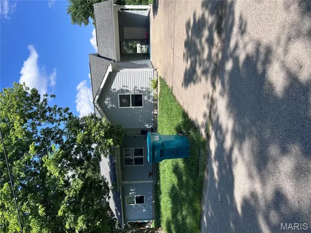 Single story home with concrete driveway, a carport, a front yard, and roof with shingles
