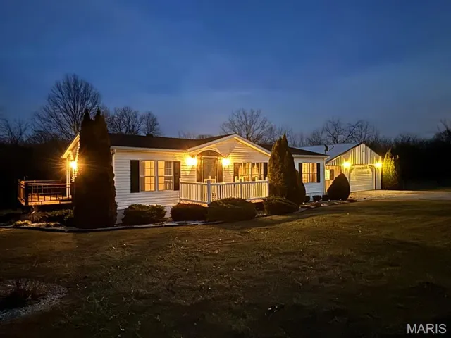 Ranch-style home with a garage and an outbuilding