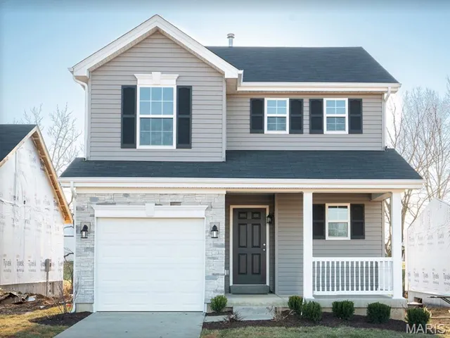 View of front of home with a porch, a garage, roof with shingles, concrete driveway, and stone siding