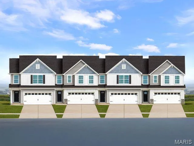 Townhome / multi-family property featuring a garage and concrete driveway