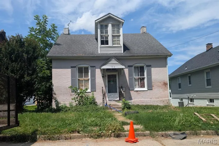 View of front of home with a chimney and brick siding