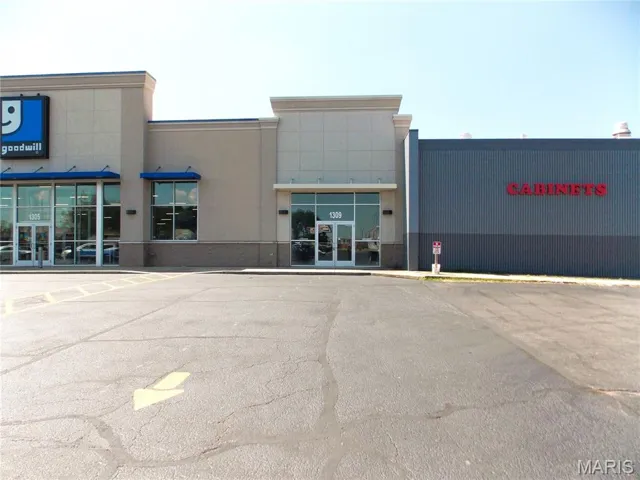 View of commercial property with uncovered parking