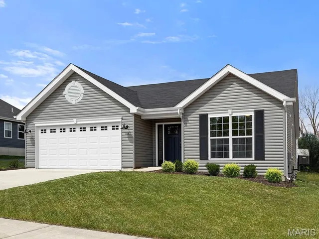 Single story home featuring an attached garage, driveway, a front yard, and a shingled roof