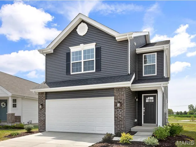 View of front of home featuring a garage, brick siding, and concrete driveway