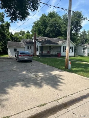 View of front of house with a porch, driveway, and a front yard
