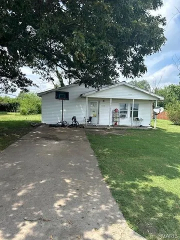 View of front of home featuring a front lawn, covered porch, and driveway