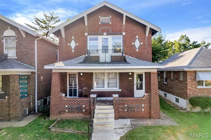 View of front of house featuring brick siding and covered porch