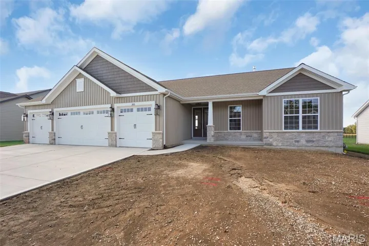 Craftsman house with stone siding, driveway, covered porch, and an attached garage