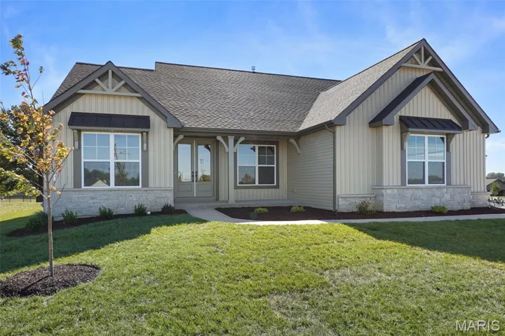 Craftsman-style house featuring stone siding, board and batten siding, and roof with shingles