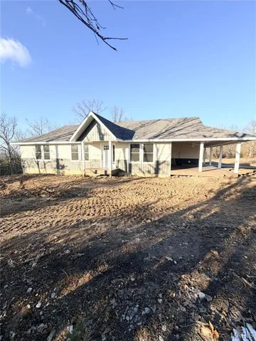 View of front of property with a shingled roof and a porch
