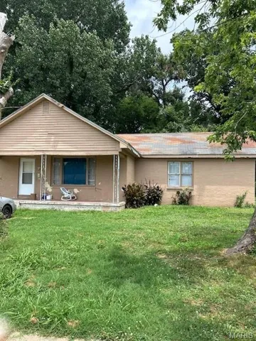 View of front of home with a front yard and covered porch