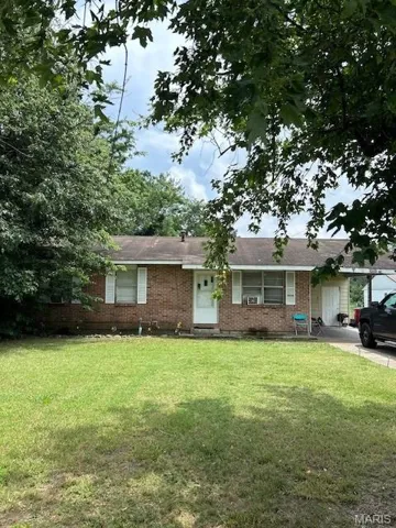 Ranch-style house with a front yard and brick siding