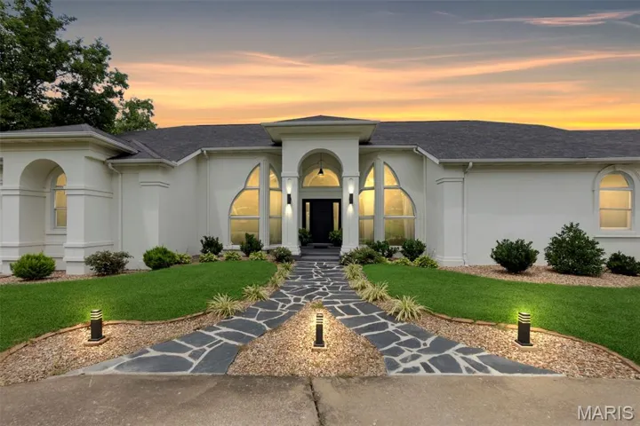 Mediterranean / spanish house with stucco siding, a front lawn, and a shingled roof