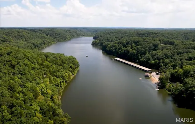 Drone / aerial view of a heavily wooded area and a large body of water