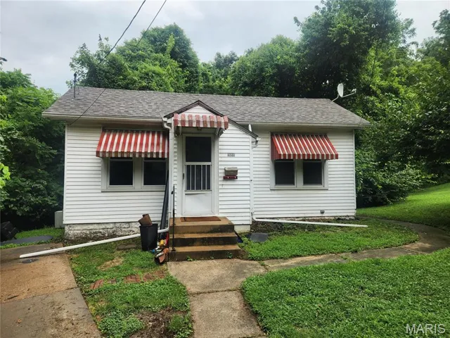 Bungalow-style home with entry steps and roof with shingles