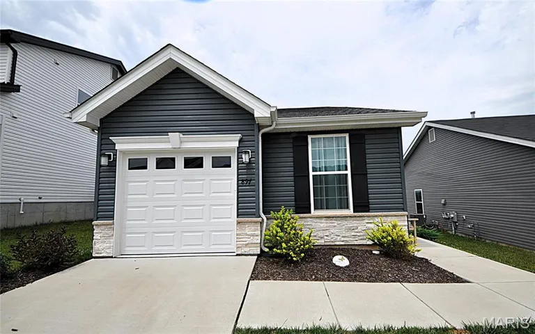 Single story home featuring stone siding, an attached garage, driveway, and a shingled roof