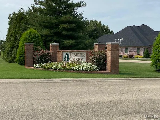Community / neighborhood sign featuring a yard