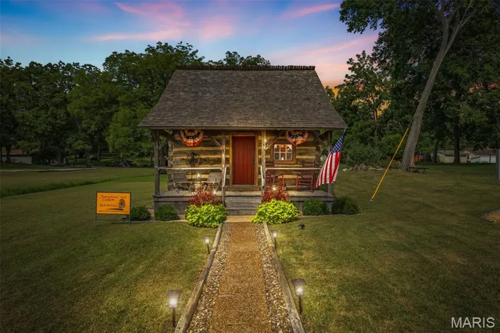 View of front facade with a lawn and a shingled roof
