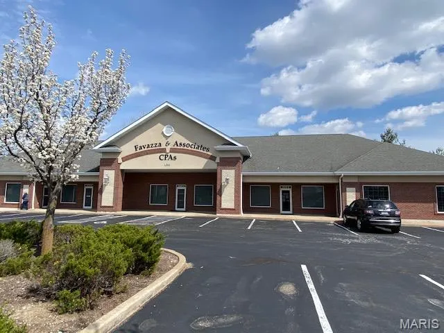 View of building exterior with uncovered parking