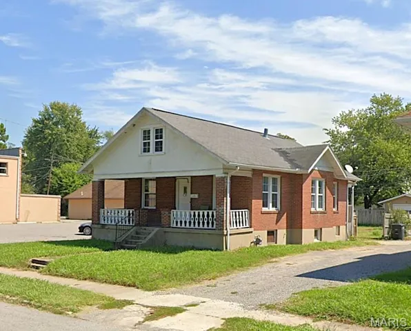 Bungalow-style home with brick siding and covered porch