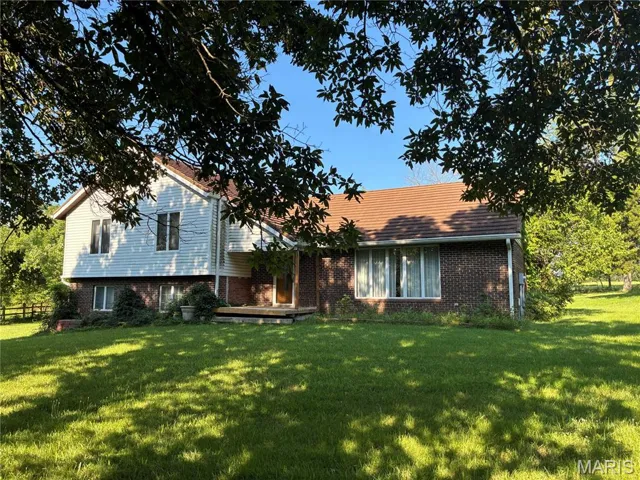 Split level home featuring brick siding and a front yard