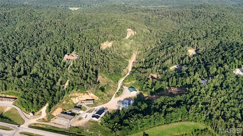 Aerial view of property's location featuring a forest