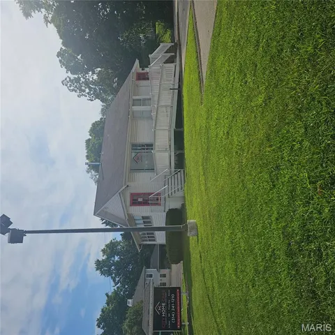 View of front facade with a front lawn and a deck