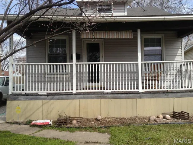 View of property exterior featuring a porch and roof with shingles