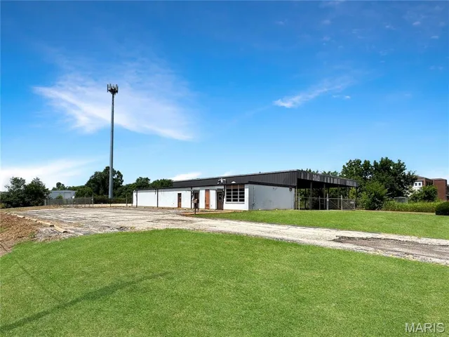View of front of house with a front yard and a detached garage
