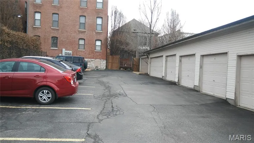 View of asphalt road featuring community garages