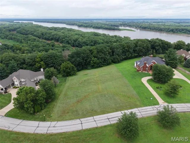 Aerial view of a nearby body of water and a heavily wooded area