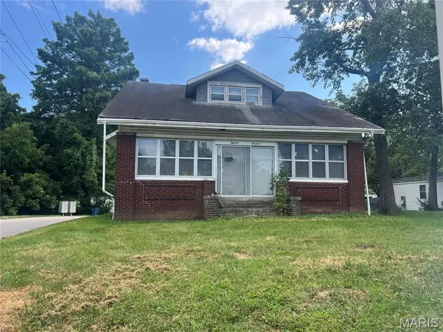 Bungalow-style home featuring a front lawn, brick siding, and entry steps