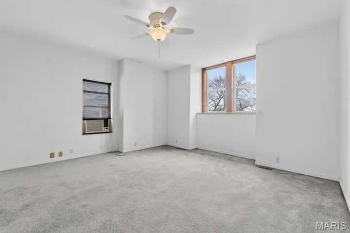 Spare room featuring healthy amount of natural light, carpet flooring, and ceiling fan