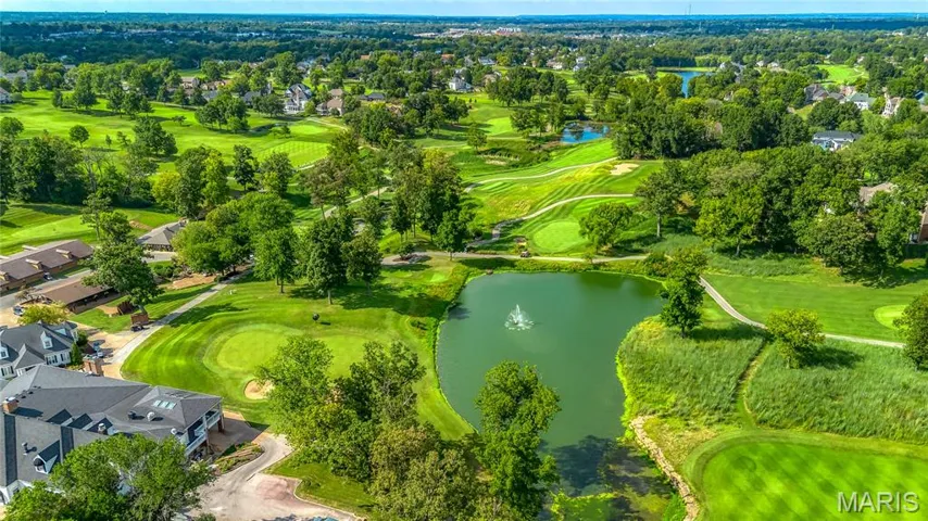 Aerial perspective of suburban area featuring a nearby body of water and a golf club